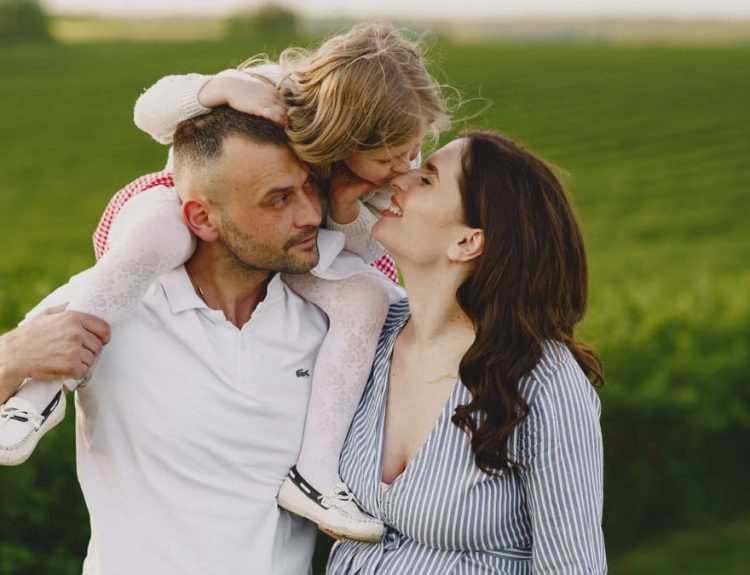 A delightful family moment captured in a lush scenic field, portraying love and happiness.